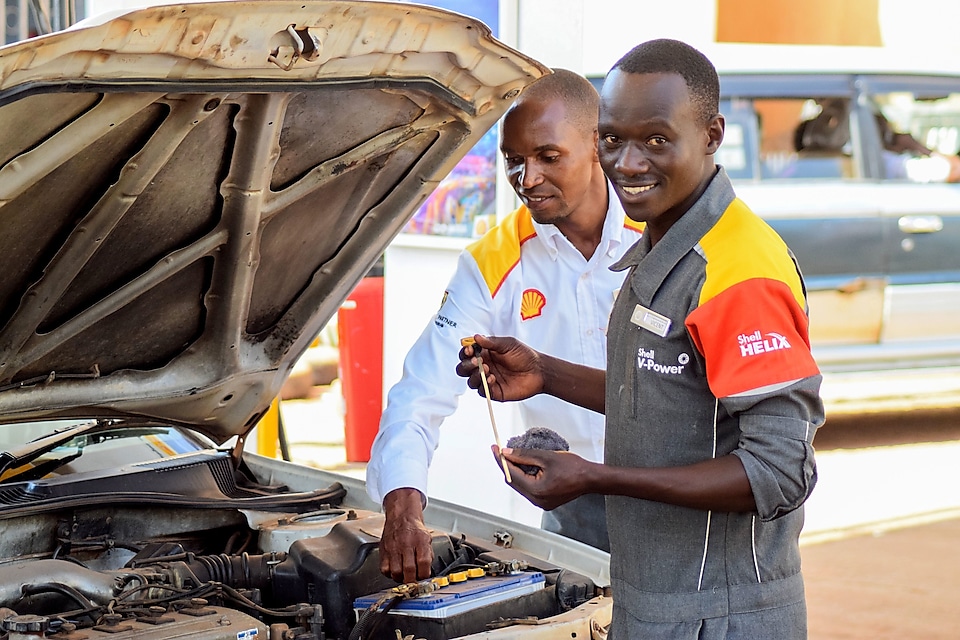 Shell assistant opening bonet of a car to check the oil