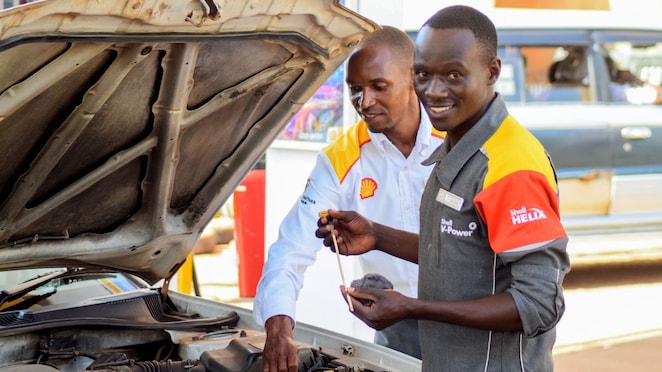 An enginner pours Shell lubricant into a car engine