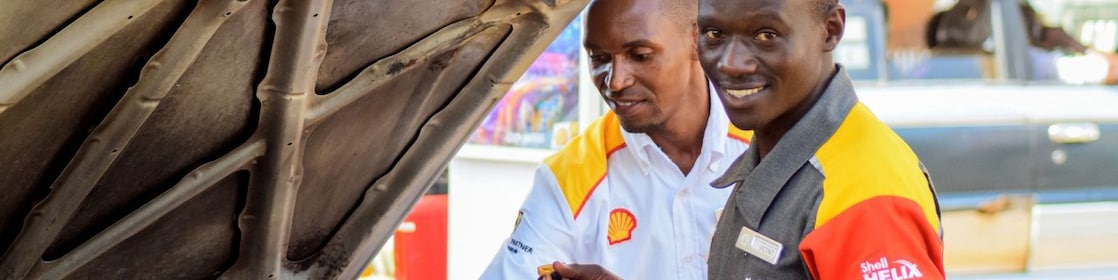 engineer pouring Shell lubricant into a car engine