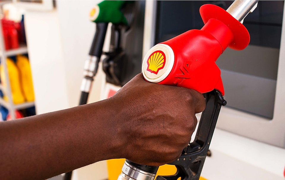 Service attendant holding a fuel nozzle