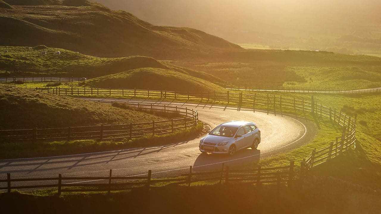 car driving in green field