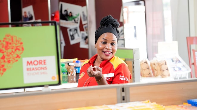 Sun rising behind a Shell station forecourt